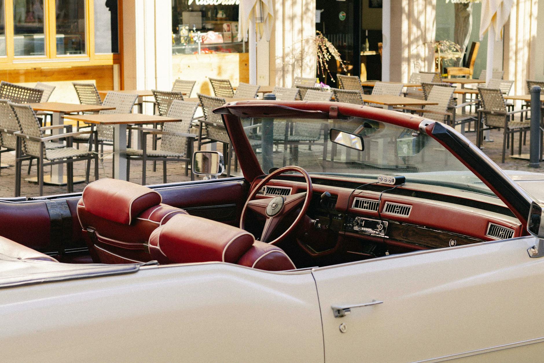 Klasyczny kabriolet zaparkowany przed kawiarnią w letniej scenerii