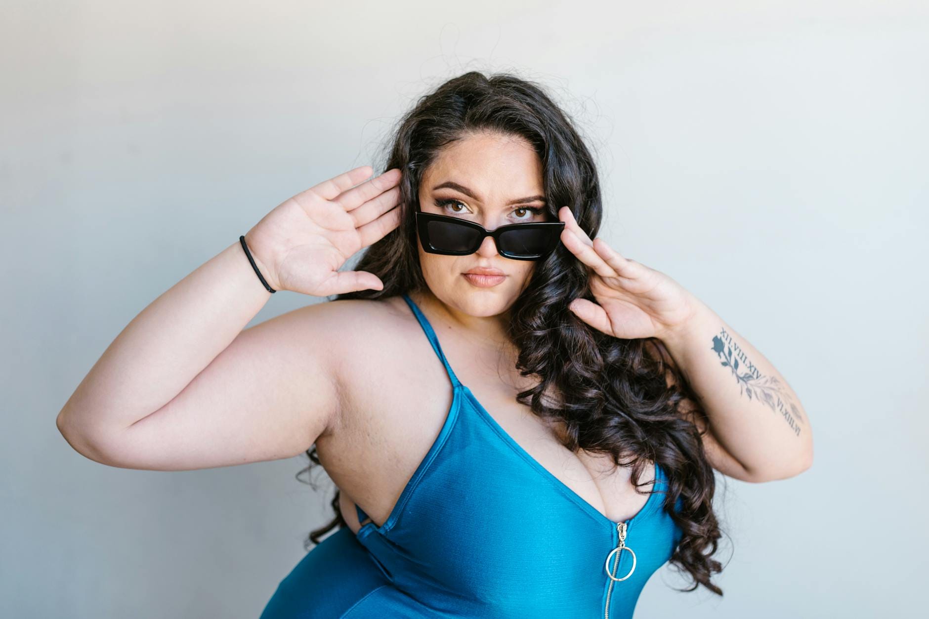 Pewna siebie kobieta plus size w niebieskim stroju kąpielowym i okularach